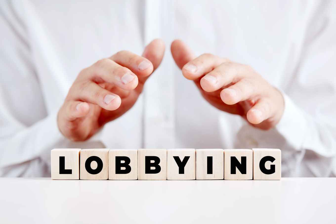 handen boven een bordje waarop 'lobbying' staat